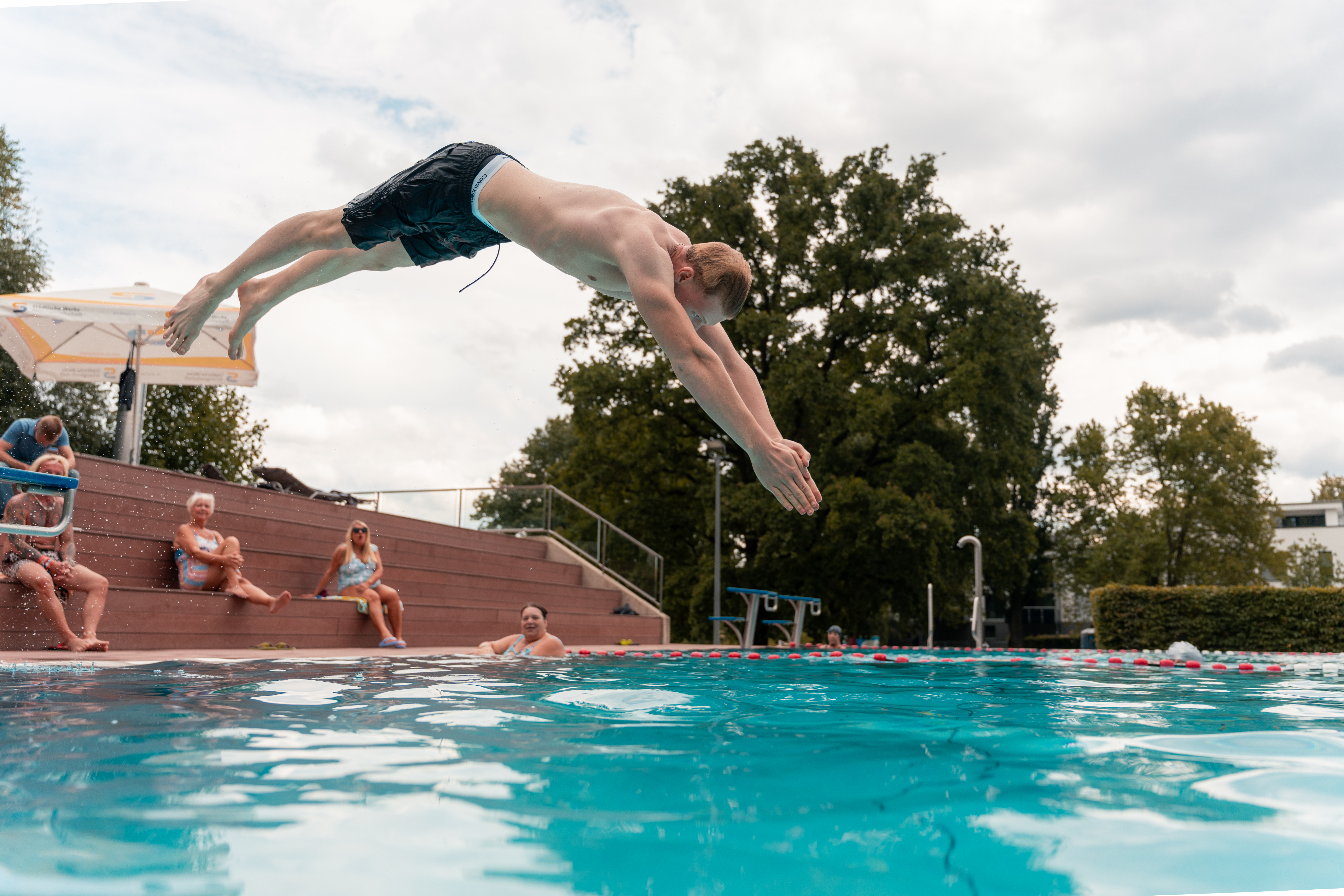 Schwimmer springt ins Becken des Freibads Harleshausen